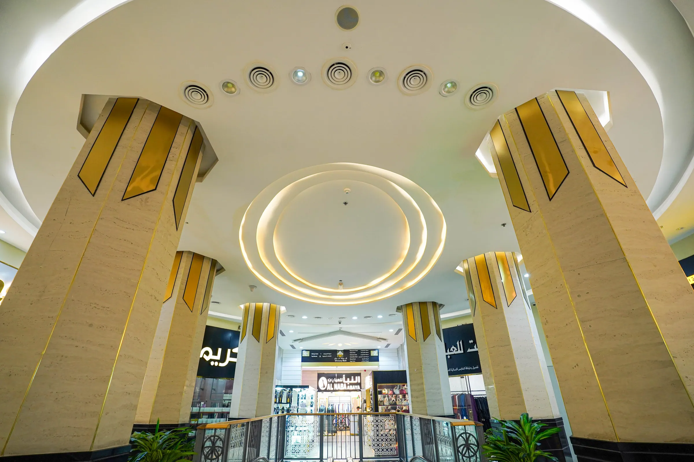 Sculpted gold column capitals under the atrium ceiling
